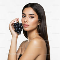 Elegant Woman with Black Grapes in a Beauty and Wellness Studio