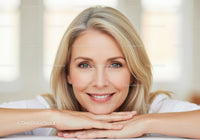 Beautiful blonde woman with blue eyes smiling in natural light