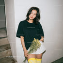 Young Woman in Casual Black T-Shirt and White Skirt Holding Flowers
