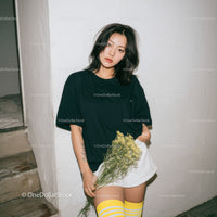 Young Woman in Casual Black T-Shirt and White Skirt Holding Flowers