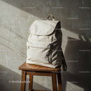 Minimalist beige backpack on wooden stool near wall