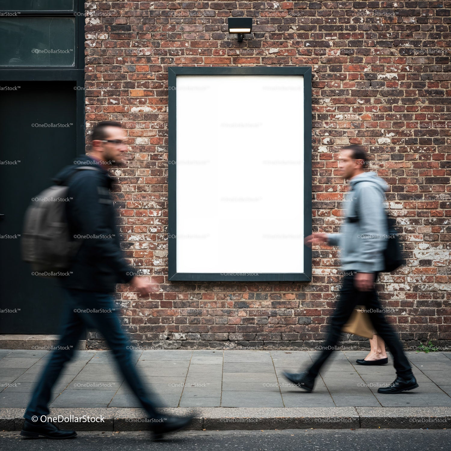 Blurred pedestrians walking past empty urban billboard