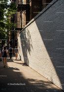 City Sidewalk with Pedestrians and Tree Shadows