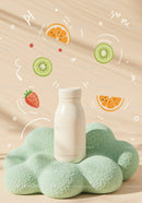 Milk bottle on soft green textured cushion with fruit