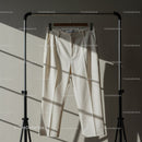 Cream Colored Dress Pants Hanging on Metal Rack