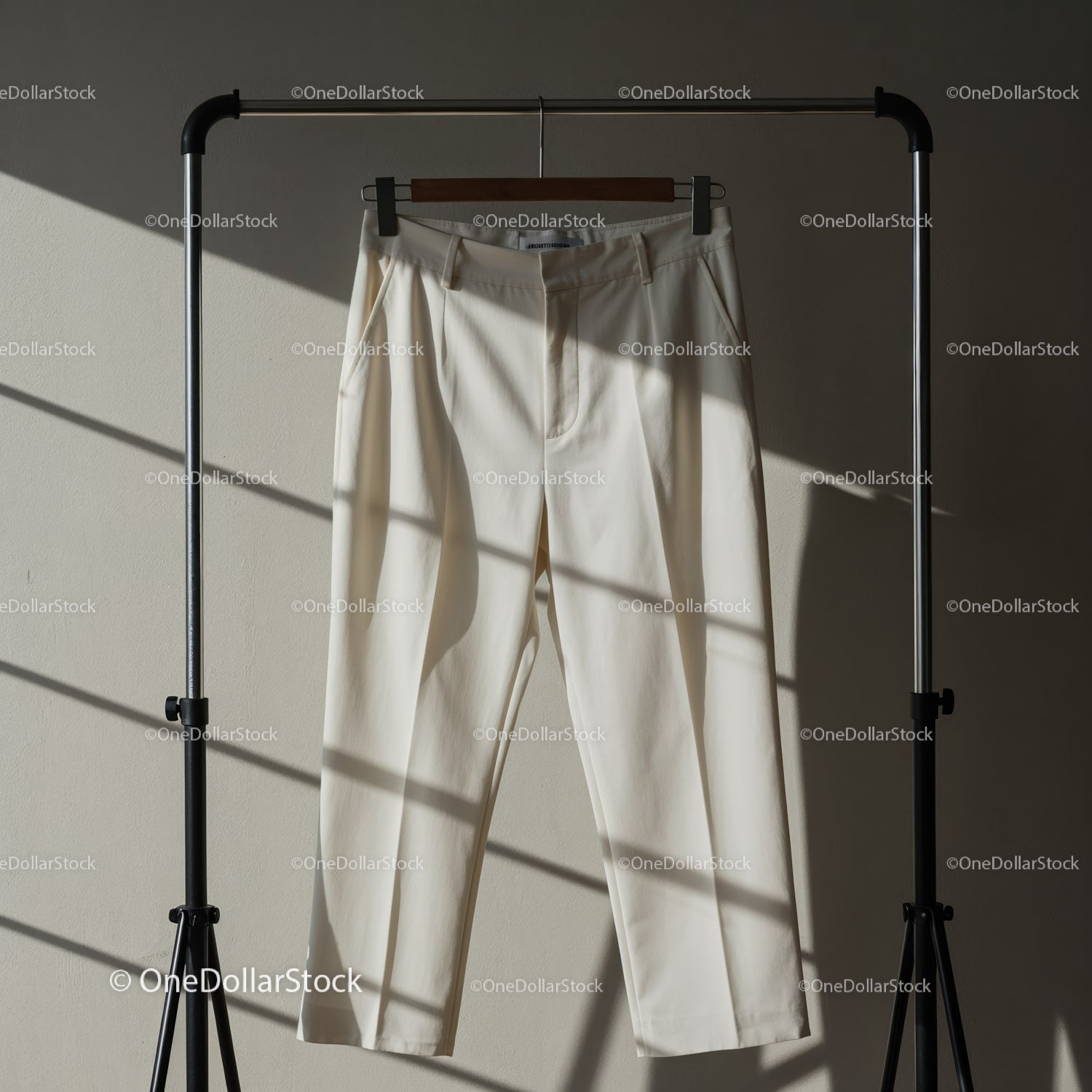 Cream Colored Dress Pants Hanging on Metal Rack