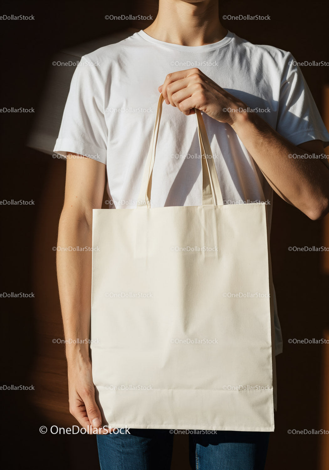 Person Holding Blank Canvas Tote Bag Against Dark Background