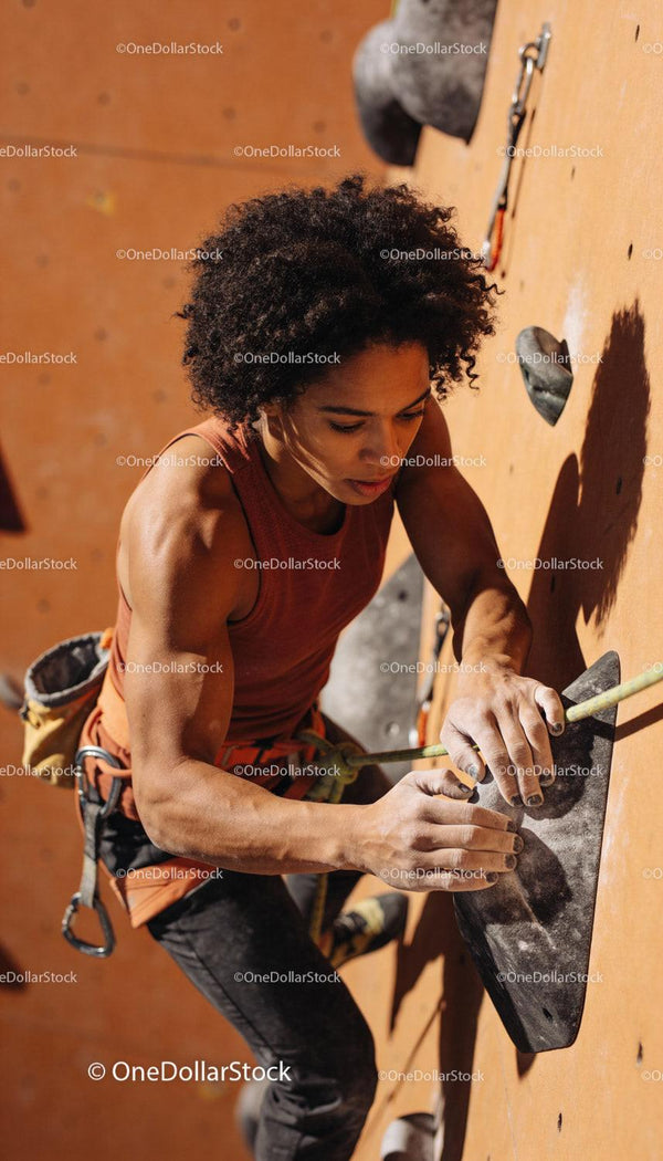 Focused woman climbing indoor rock wall