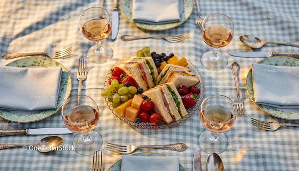 Elegant outdoor picnic with sandwiches and fresh fruits