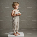 Toddler boy holding cupcake standing on white block