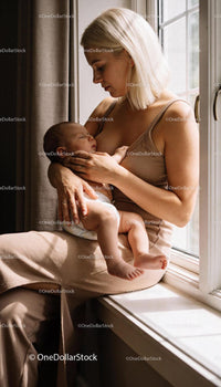 Mother tenderly cradling sleeping baby by the window