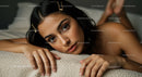 Portrait of a Beautiful Woman with Dark Hair and Brown Eyes Resting on Soft Surface