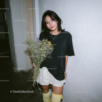 Young Woman Holding Bouquet of Lavender and Wildflowers in Indoor Setting