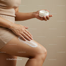 Woman Applying Body Lotion with Skincare Jar in Minimalist Setting
