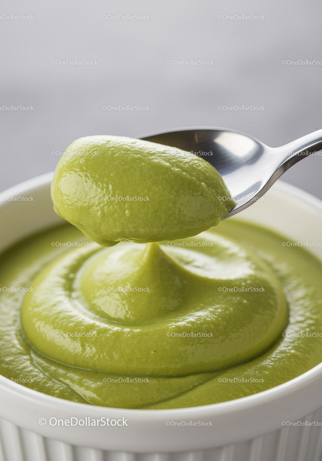 Creamy green avocado mousse in white ramekin with spoon