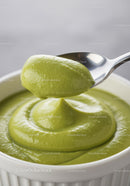 Creamy green avocado mousse in white ramekin with spoon