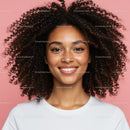 Confident Smiling Woman with Curly Hair in Studio Portrait