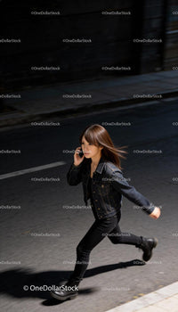 Young woman walking fast while talking on phone