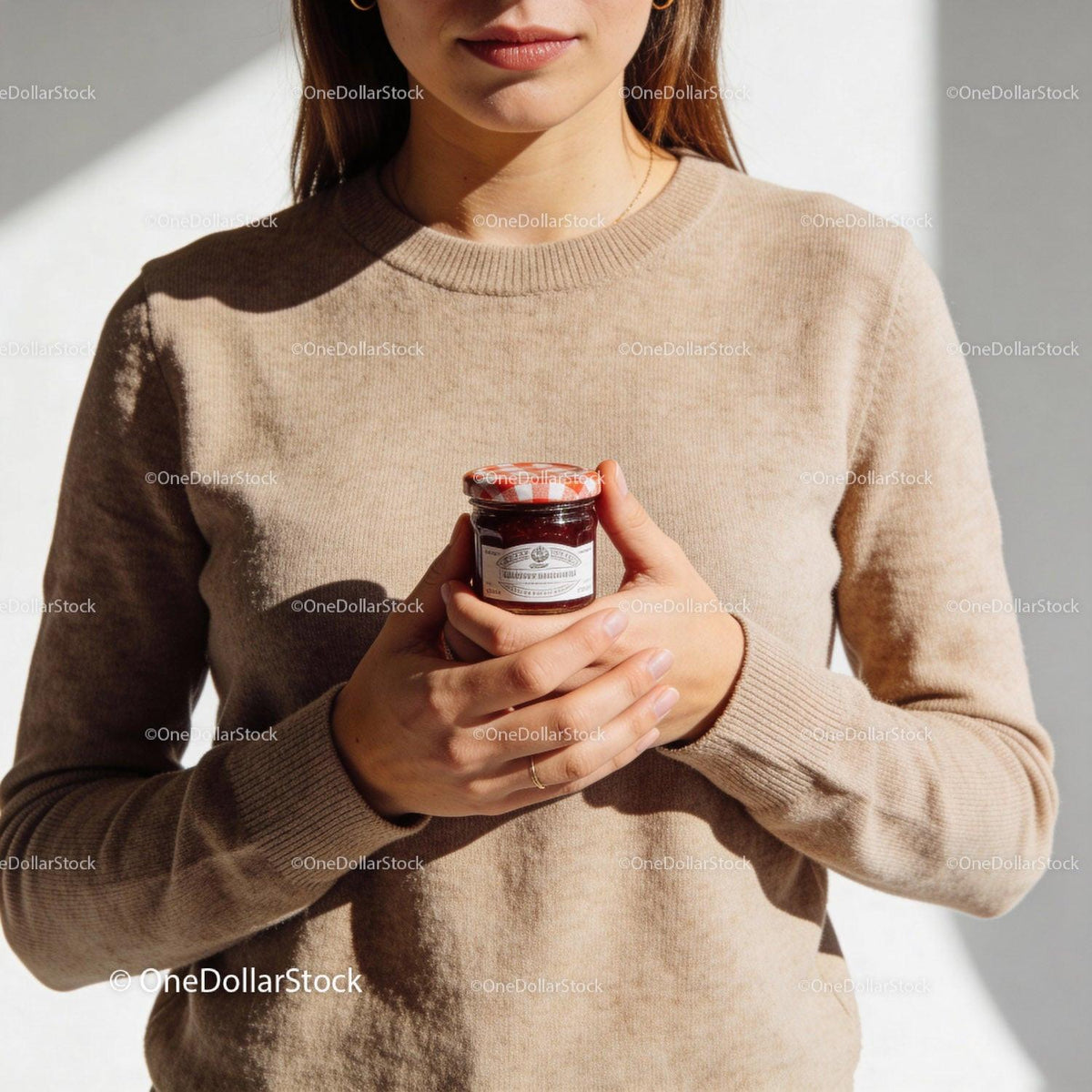 Woman Holding Small Jar of Red Jam Close to Chest