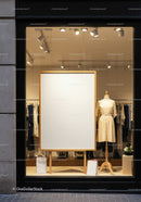 Elegant dress display with blank poster in fashion store window