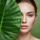 Close-Up Portrait of a Woman with Blue Eyes Behind Green Leaf with Water Droplets