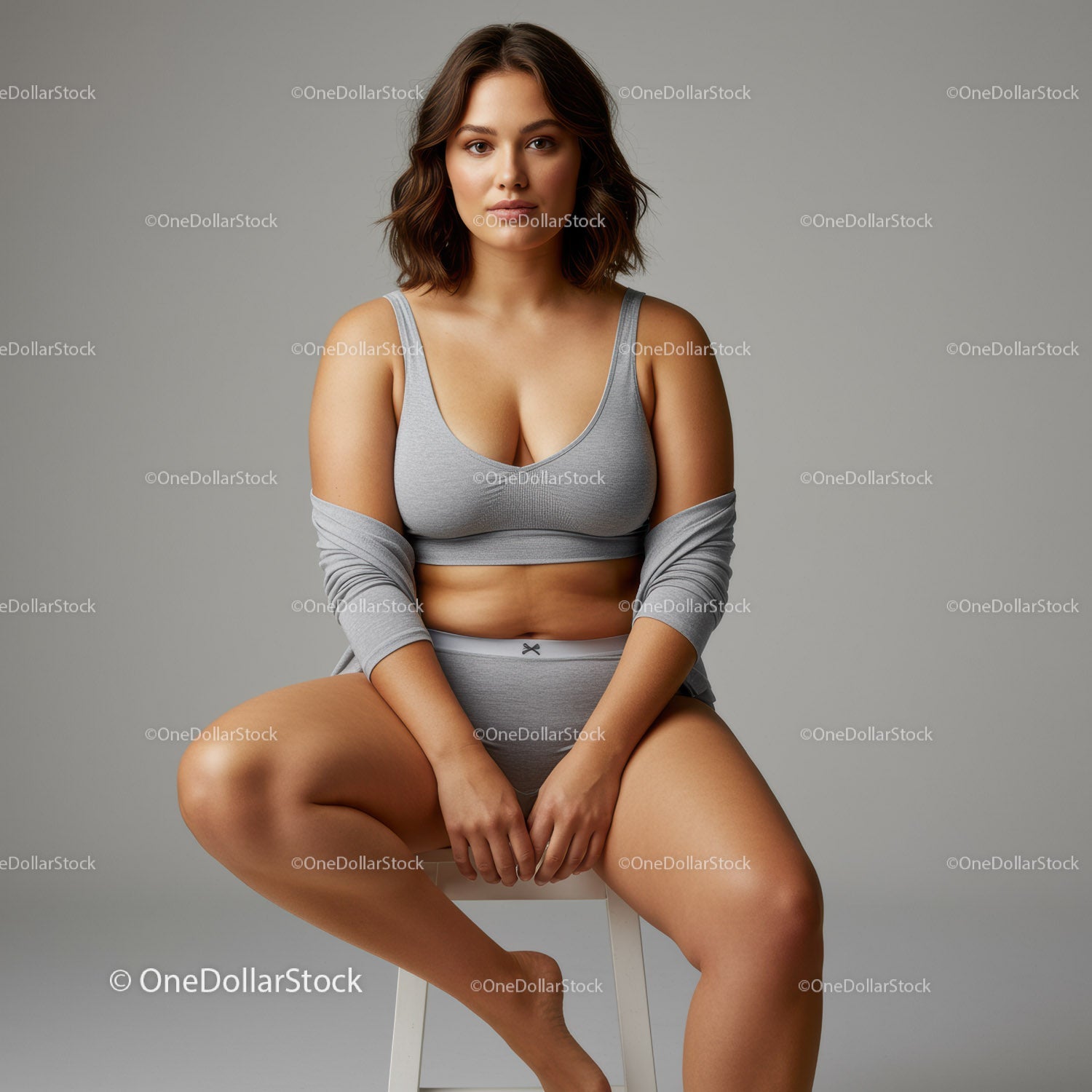 Young Woman Sitting in Gray Sportswear on Studio Chair For Lifestyle Photo