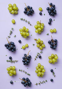 Fresh Green and Black Grapes with Herb Sprigs on Lilac