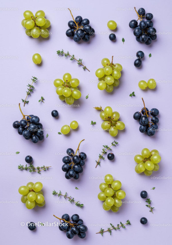 Fresh Green and Black Grapes with Herb Sprigs on Lilac