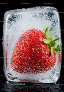 Fresh strawberry frozen inside a clear ice cube