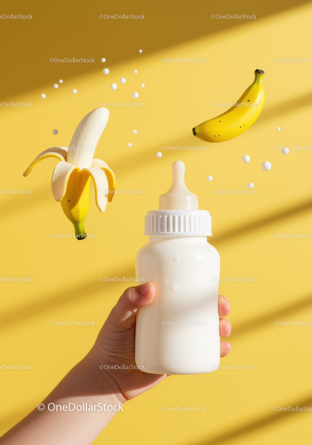 Dłoń dziecka trzymająca butelkę mleka z unoszącymi się bananami