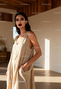 Confident woman in loose beige dress with dark lipstick