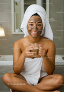 Smiling Woman Relaxing with Facial Mask and Tea at Home