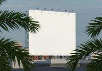 Blank outdoor billboard framed by tropical palm leaves