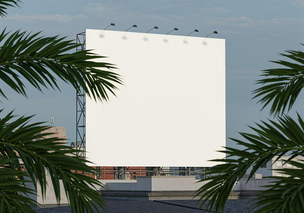 Blank outdoor billboard framed by tropical palm leaves JPG Mockup Image