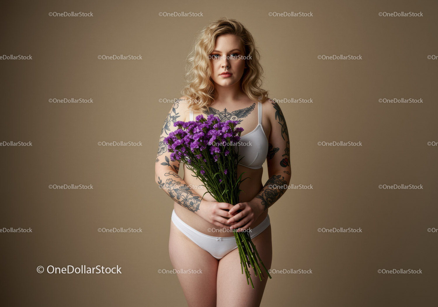 Woman with Multiple Tattoos Holding Purple Flower Bouquet in Studio