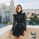 Elegant Woman in Black Lace Dress with City Skyline Background
