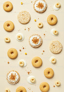 Assorted crunchy cookies and creamy dollops on beige surface