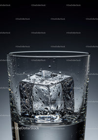 Close up of glass with melting ice cube and water droplets