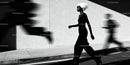 Woman with White Hair Walking Against Light Wall