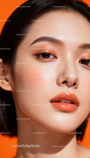 Close up of woman with glowing skin and orange makeup