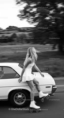 Young woman roller skating alongside vintage car