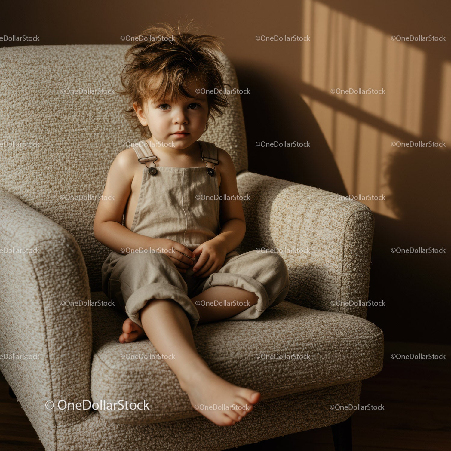 Thoughtful toddler sitting on cozy armchair indoors