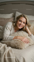 Blonde woman relaxing on soft bed with cozy pillow
