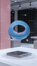 Floating Blue Glass Ring with Laptop in Modern Interior