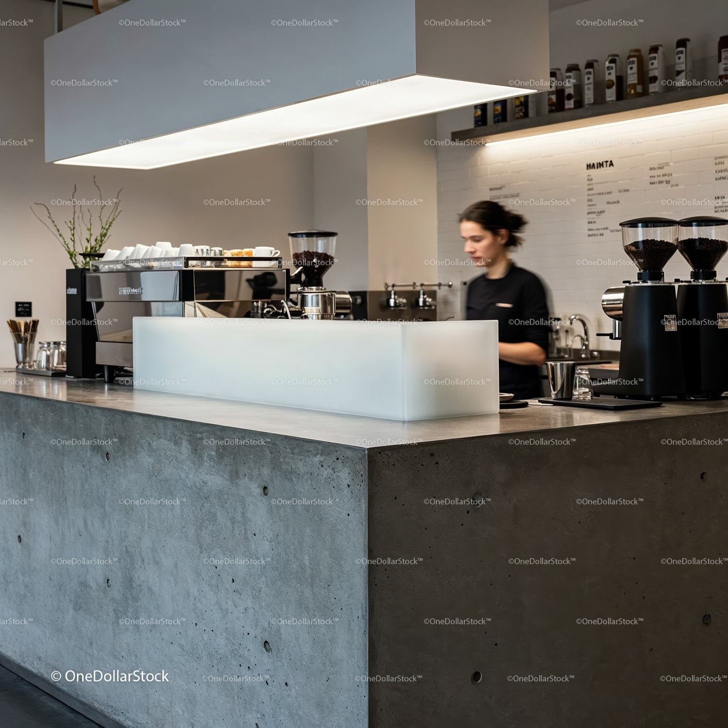 Barista preparing coffee behind modern concrete counter