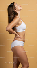Healthy Fitness Woman in White Sportswear Leaning Against Beige Background