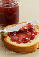 Spreading Red Berry Jam on Fresh Bread Slice