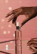 Elegant Black Hand Applying Serum from Dropper Bottle in Beauty Routine