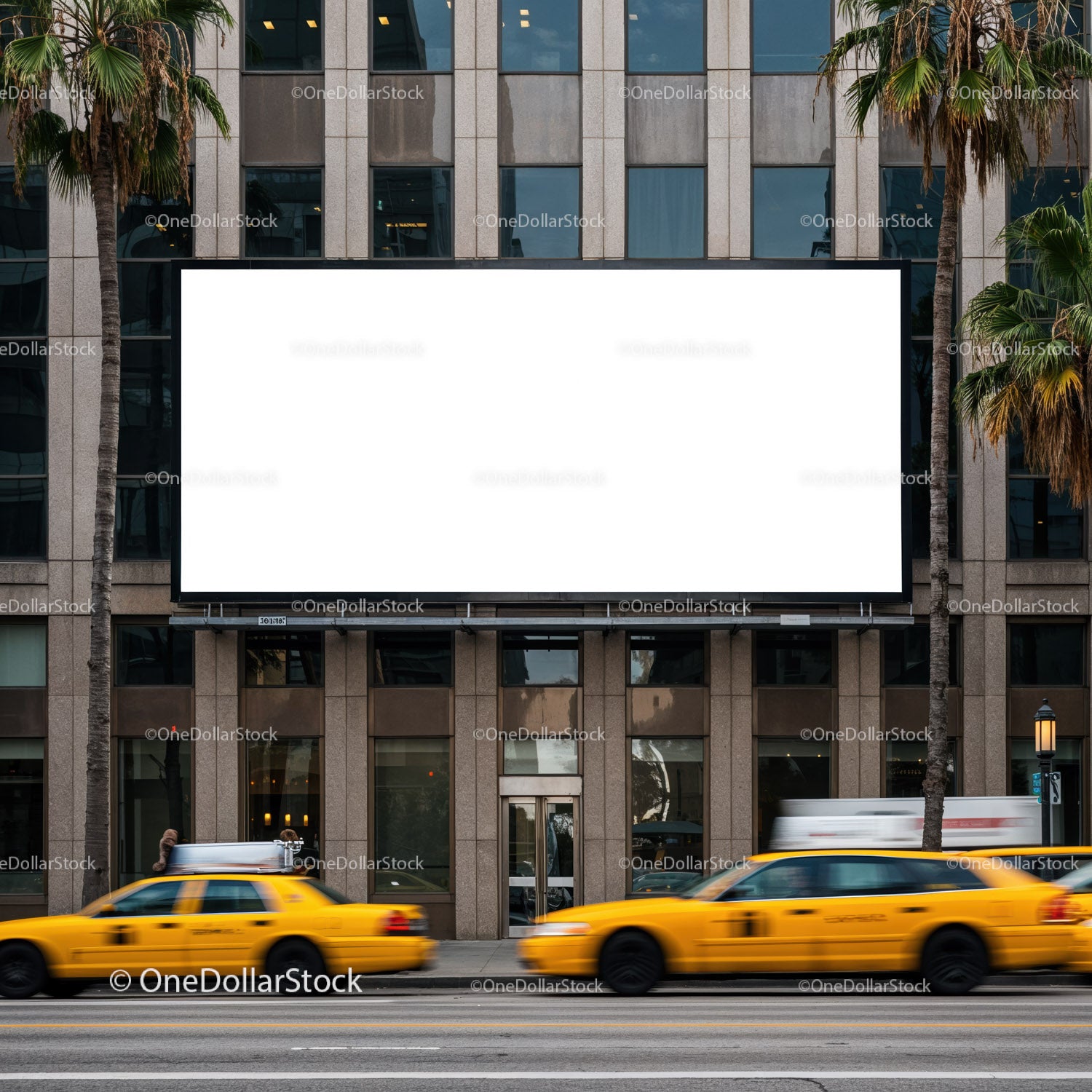 Żółte taksówki miejskie przejeżdżające obok pustego billboardu w mieście