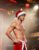 Fit man in Santa hat and festive pants in cozy club